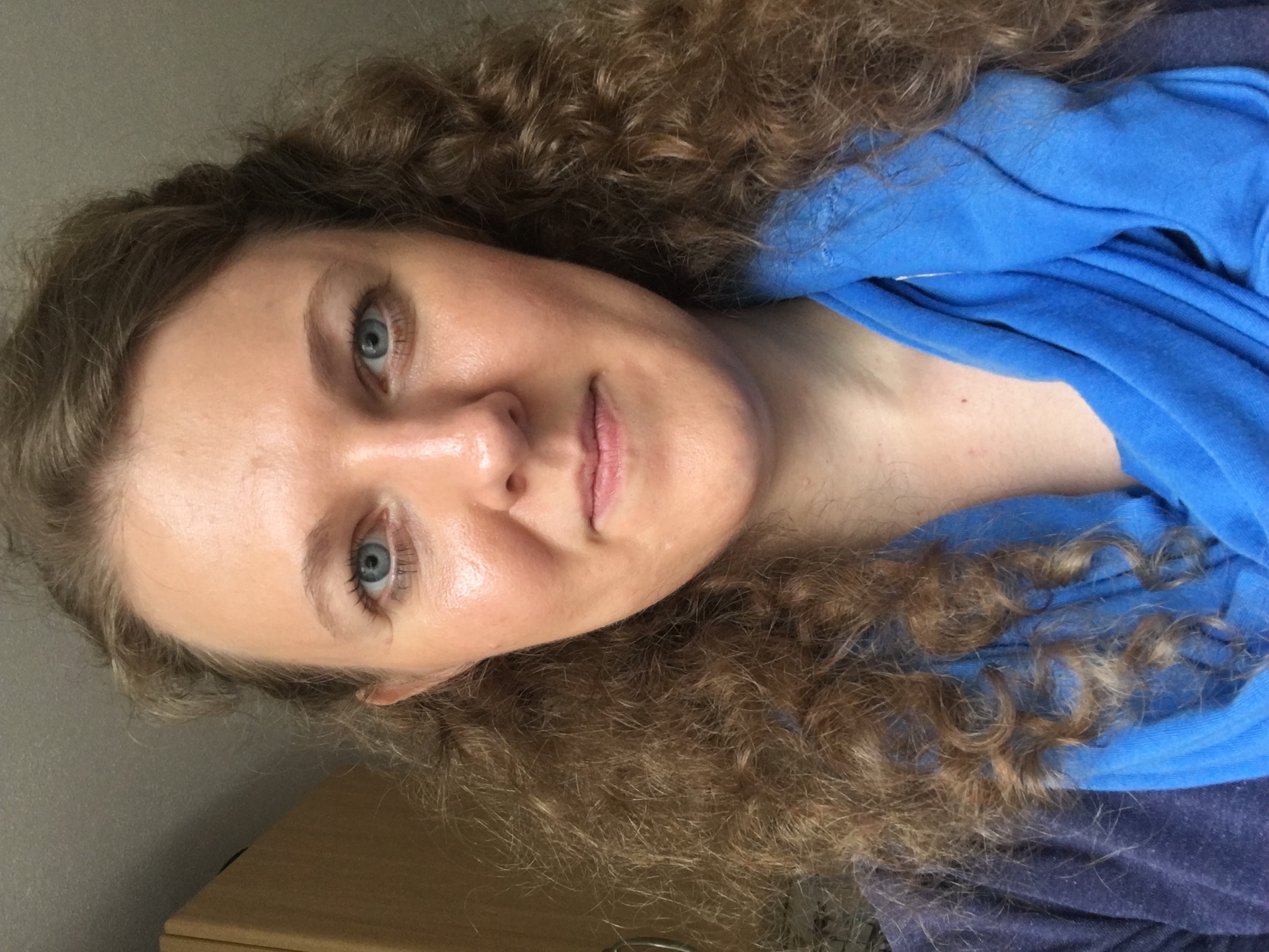 Freundliche Frau mit blauem Schaltuch und lockigem Haar